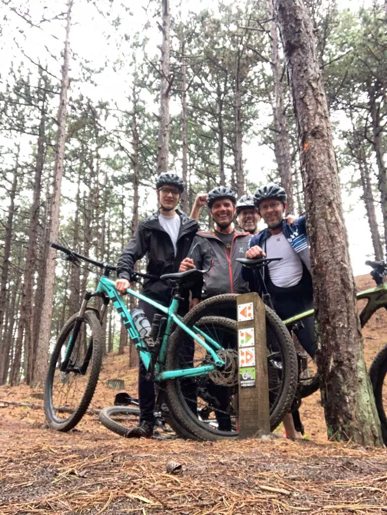 Vier mountainbikers van Dirtbags & Mudbabes in het bos bij Bergen